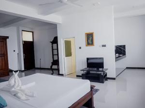 a white room with a bed and a tv at Ocean River View in Ambalangoda