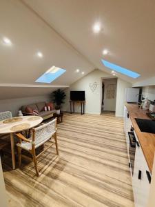 a kitchen and a living room with a table and chairs at Les hébergements Rousseau in Oyonnax