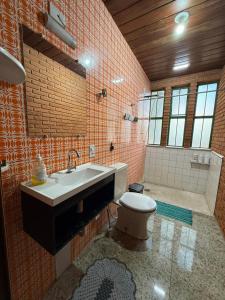 a bathroom with a sink and a toilet at Quarto confortável no Centro in Botucatu +21 photos