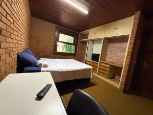 a small room with a bed and a desk at Quarto confortável no Centro in Botucatu