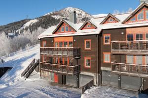 a building in the snow with a mountain in the background at Åre Travel-Tottbacken 1 in Åre