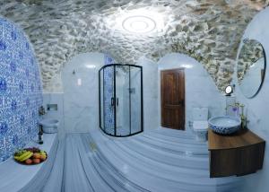 a bathroom with a shower and a toilet and a sink at Kasr-ı Kikan Hotel in Mardin +68 photos