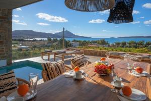 a dining table with a view of the ocean at Penthouse Villa with Private Pool, Sauna & Seaview in Gialova