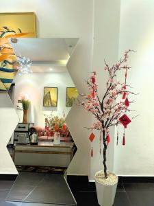 a tree in a vase in a room at A In Hotel Glamour in Ho Chi Minh City