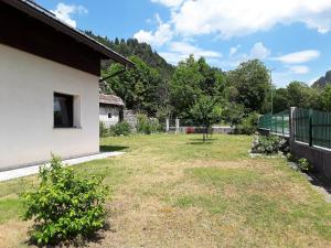 a yard next to a building with a fence at Casa Vacanze Da Ile 2 in Malborghetto Valbruna