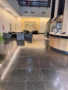 an empty lobby with chairs and a sign on the wall at Luix Londrina Flat 707, QS 43 m2 , ar quente e frio, c garagem in Londrina +26 photos