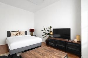 a bedroom with a bed and a flat screen tv at 2 Bedroom Apartment for Families and Business, Tram and Bus in Front in Antwerp
