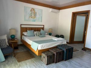 a bedroom with a bed and a pile of luggage at Lakaz Zoizo in Crève Coeur