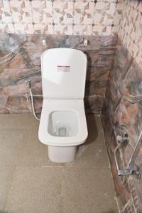 a bathroom with a white toilet in a room at pitambara studio apartment with kitchen in Karadoho