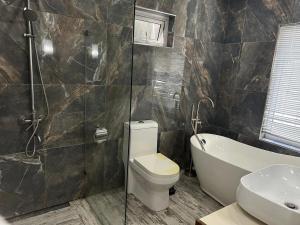 a bathroom with a toilet and a tub and a sink at Lakaz Zoizo in Crève Coeur
