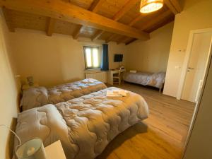 a bedroom with two beds in a room with wooden ceilings at Casale La Rosa Azzurra in Ponte Buggianese