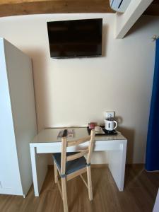 a desk with a chair and a television on a wall at Casale La Rosa Azzurra in Ponte Buggianese