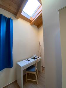 a room with a table with a blue chair and a window at Casale La Rosa Azzurra in Ponte Buggianese