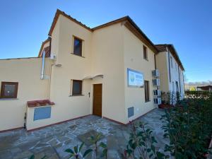 a large white building with a stone courtyard at Casale La Rosa Azzurra in Ponte Buggianese