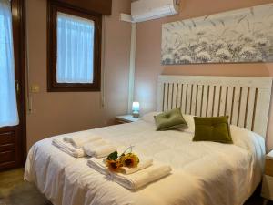 a bedroom with a bed with towels and flowers on it at Los Henares 3 in Olombrada +25 photos
