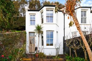 a white house with a wall at Hastings View in Hastings