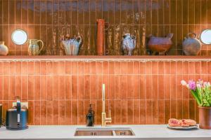 a kitchen with a sink and shelves with vases at Hastings View in Hastings +23 photos