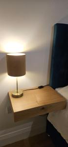 a lamp on a wooden table next to a bed at Sullane Weirs in Macroom