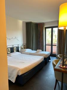 a hotel room with two beds and a window at Hotel Giò Wine e Jazz Area in Perugia +50 photos