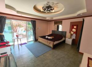 a bedroom with a bed and a room with a balcony at The Phen House in Hua Hin