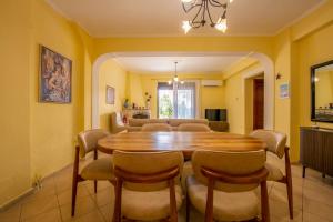 a dining room with a wooden table and chairs at Aurora Apartment in Afitos