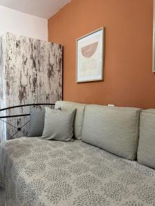a bed in a room with an orange wall at SO SIMPLE mouresi in Mouresi