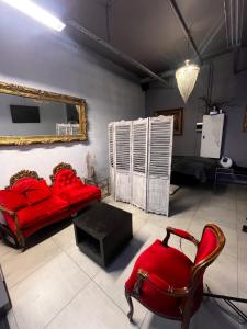 a living room with a red couch and a chair at Royal Velvet Studio in Kristiansand