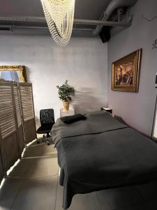 a bedroom with a bed and a chandelier at Royal Velvet Studio in Kristiansand