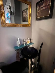 a bathroom with a sink and a mirror at Royal Velvet Studio in Kristiansand