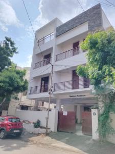 a white building with a car parked in front of it at HoTEL K7 in Chennai