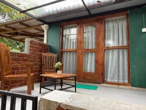 a porch with a wooden door and a table and a chair at Sigiriya Lantern Homestay in Sigiriya