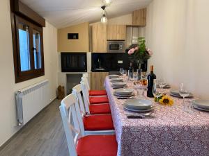 a long table with red chairs and a table with plates at Los Henares 3 in Olombrada