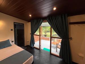 a bedroom with a bed and a sliding glass door at Sigiriya Lantern Homestay in Sigiriya