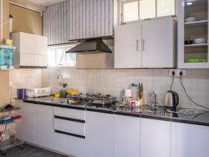 a kitchen with white cabinets and a counter top at Teecee in Āīzawl