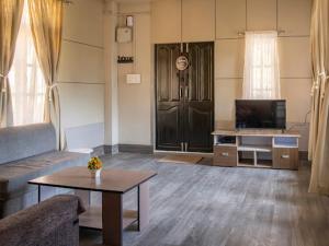 a living room with a couch and a tv and a table at Teecee in Āīzawl