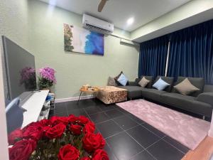 a living room with a couch and red roses at 9 Home Phuket in Ban Rangeng