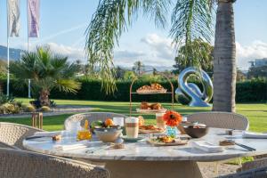 a table with food on it with palm trees at Boho Club Marbella - a Preferred Hotel in Marbella