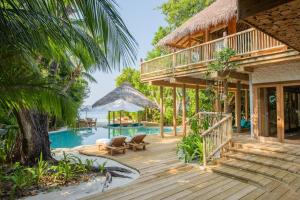 a house with a deck and a swimming pool at Soneva Fushi in Baa Atoll +73 photos