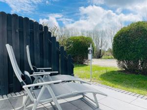a chair sitting in front of a fence at Apartment Pangani Teichhof Fehmarn in Wenkendorf
