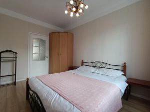 a bedroom with a large bed and a chandelier at AURA on Erkindik boulevard in Bishkek