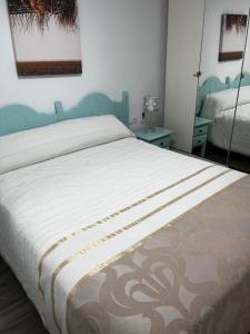 a bedroom with a bed with a blue headboard and a mirror at La casita de la punta in Isla del Moral