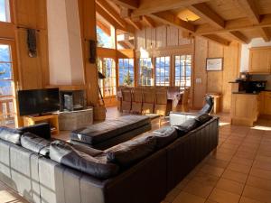 a large living room with leather couches and a fireplace at Chalet Rosablanche in Veysonnaz +19 photos