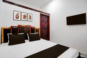 a bedroom with a bed with a tv on a wall at Hotel O Shiv Shakti Inn in Sangrāmgarh +21 photos