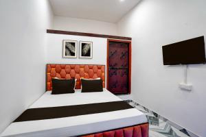 a bedroom with a bed and a tv on a wall at Hotel O Shiv Shakti Inn in Sangrāmgarh