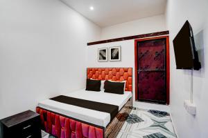 a bedroom with a bed and a flat screen tv at Hotel O Shiv Shakti Inn in Sangrāmgarh