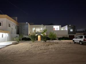 a white car parked in front of a house at night at ESSERa in Nouakchott