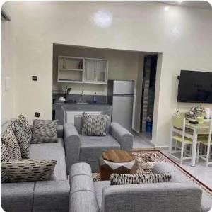 a living room with two couches and a kitchen at ESSERa in Nouakchott