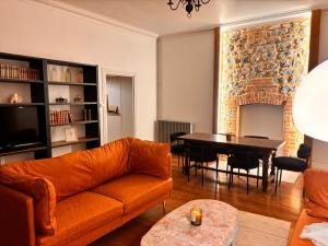 a living room with a couch and a table at Le Clair-Obscur in Paray-le-Monial