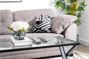 a coffee table with a vase of flowers on a couch at Stylish Apartment - Twin Beds - Parking - Fast Wi-Fi 9CC in Birmingham +27 photos