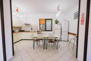 eine Küche mit Tisch, Stühlen und Kühlschrank in der Unterkunft Vila Rigo Sovata in Sovata